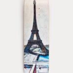 Foto de un skate con la Torre Eiffel al fondo desde Trocadero, capturando la icónica arquitectura parisina y la cultura del skate.